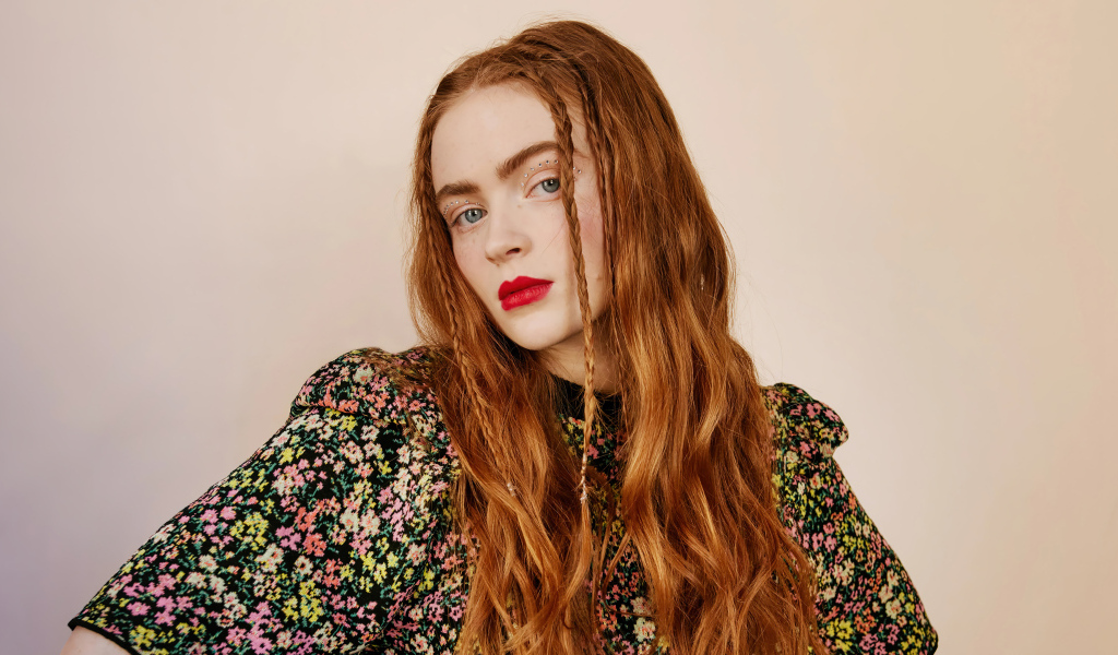 Рыжеволосая Сэди Синк на розовом фоне