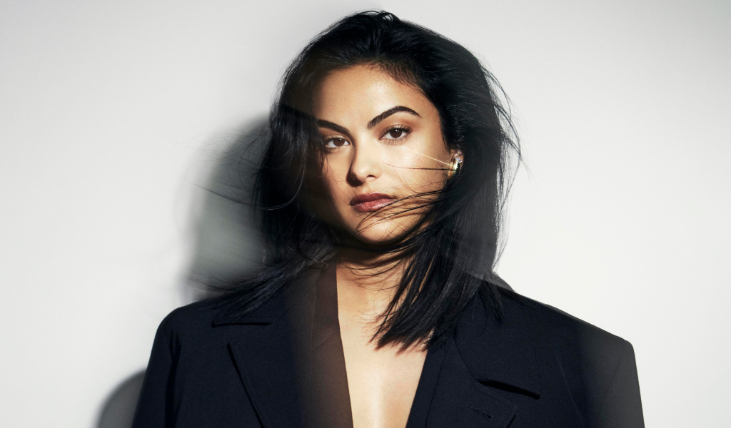 Стильная актриса Камила Мендес в черном пиджаке на сером фоне