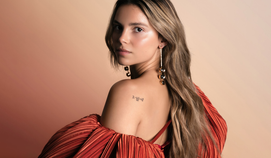 Стильная девушка актриса Инде Наварретт на розовом фоне