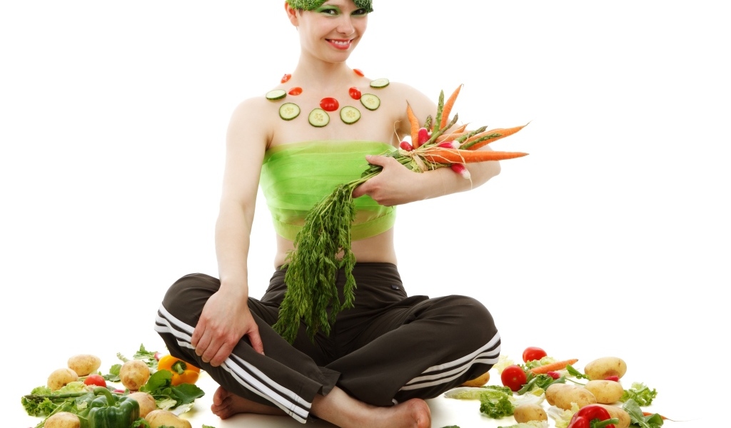 Девушка вегетарианка с овощами на белом фоне