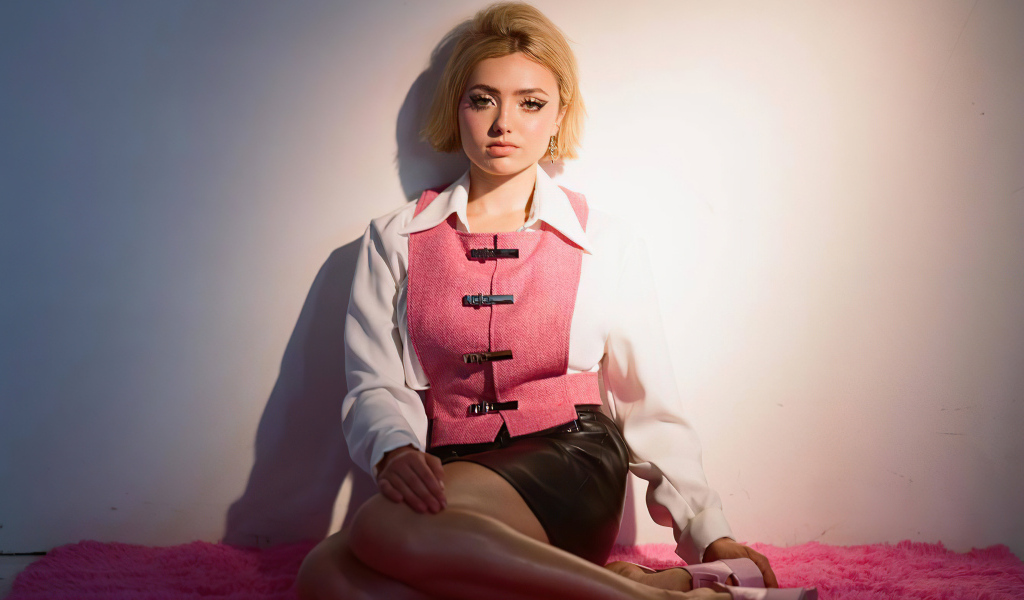 Молодая девушка Пейтон Рой Лист сидит у стены