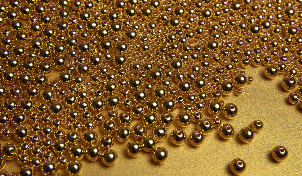 Много золотых бусин на желтом фоне