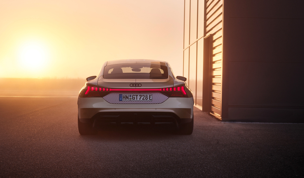 Вид сзади на автомобиль Audi RS E-Tron GT Prototype на фоне солнца