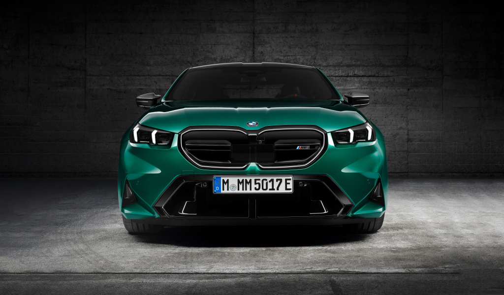 Зеленый автомобиль BMW M5 2024  года вид спереди