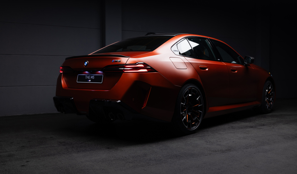 Вид сзади на красный автомобиль BMW M5 2025 года