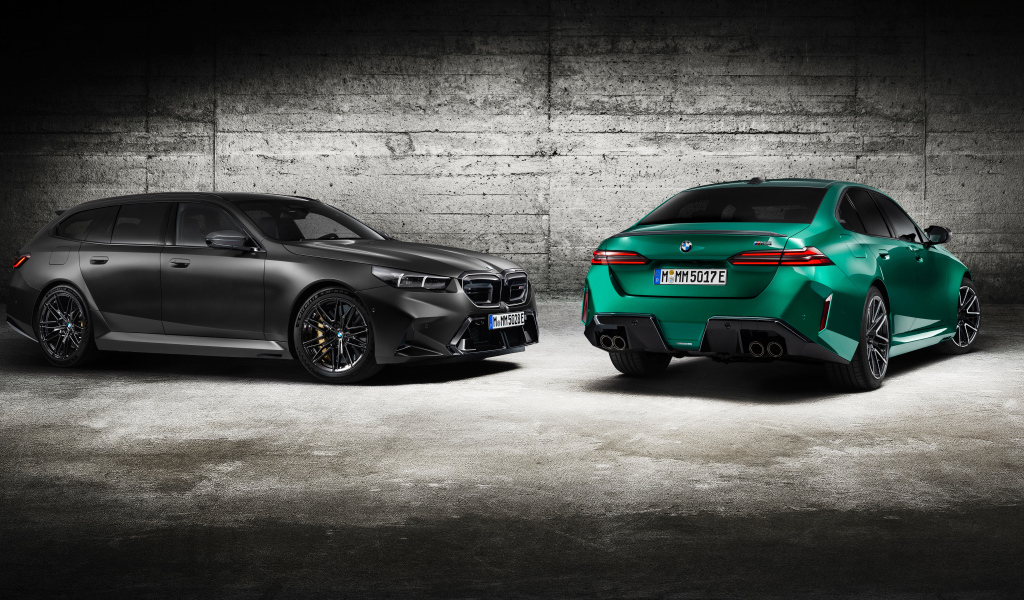 Два автомобиля BMW M5 2024 года на фоне серой стены