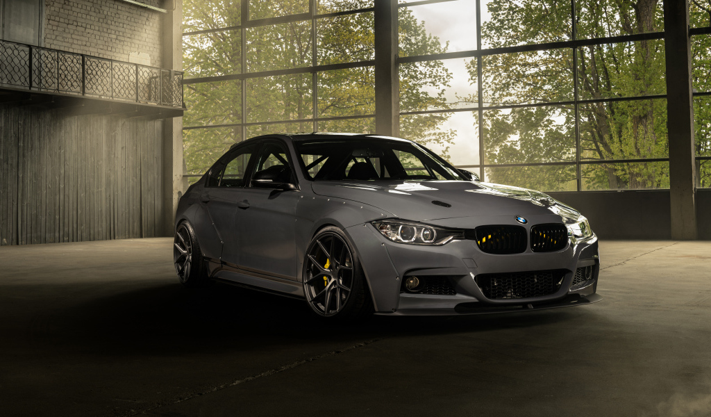 Белый автомобиль BMW F30 Widebody в здании