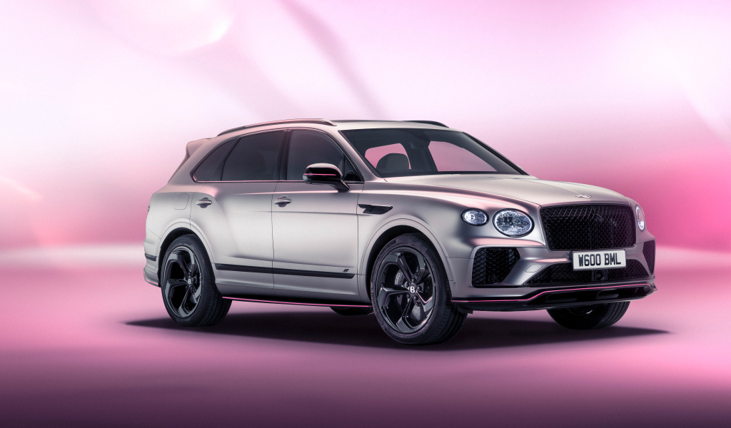 Серебристый автомобиль Bentley Bentayga V8 S Curated By Mulliner 2024 года на розовом фоне