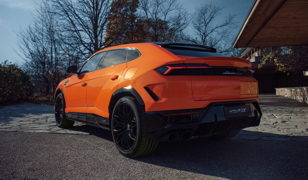 Вид сзади на оранжевый внедорожник Lamborghini Urus SE Plug-In Hybrid
