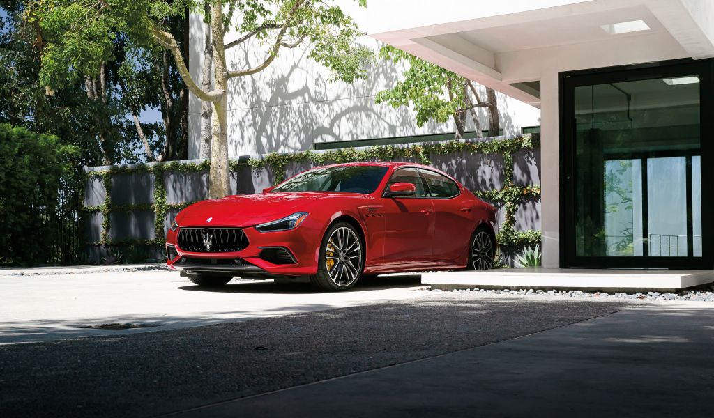 Красный автомобиль Maserati Ghibli Trofeo у дома