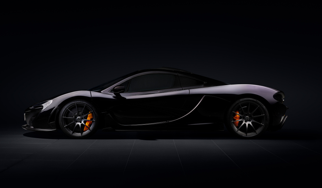 Вид сбоку на автомобиль McLaren P1 на черном фоне
