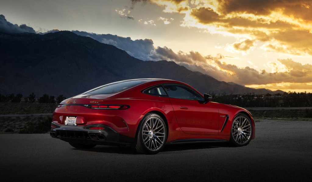 Вид сзади на красный автомобиль Mercedes-AMG GT 63 4MATIC+ 2024 года на закате