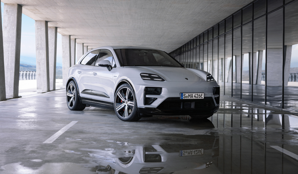 Большой Porsche Macan Turbo 2024 года у здания