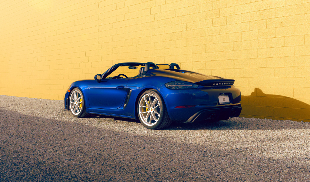 Вид сзади на синий автомобиль Porsche 718 Spyder