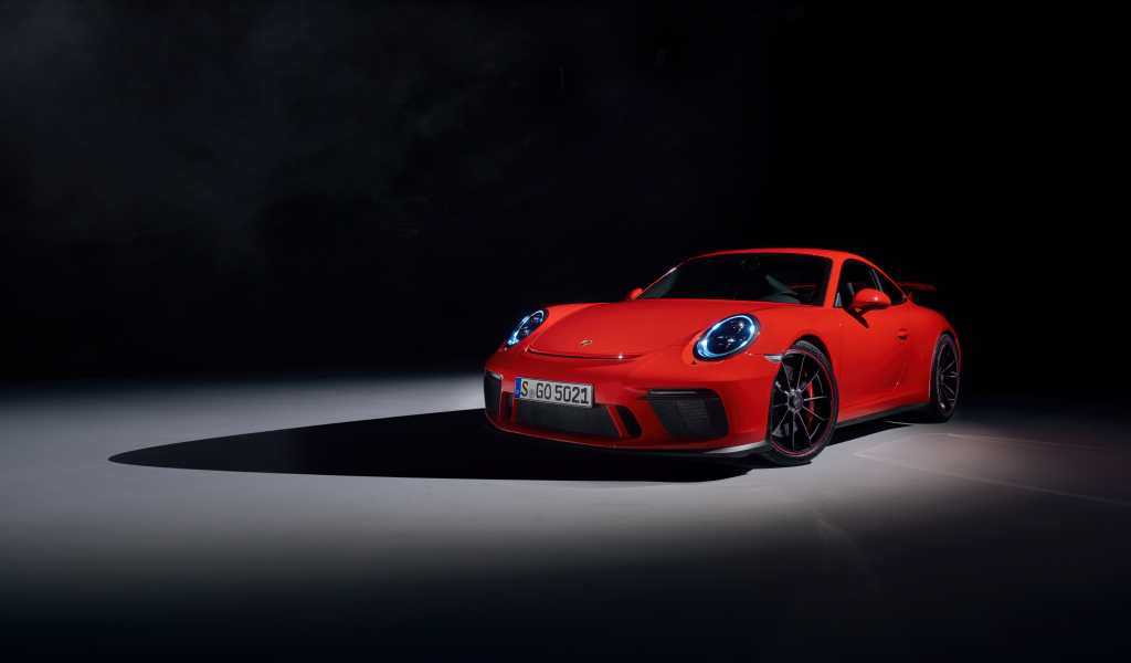 Красный автомобиль Porsche 911 GT3 на черном фоне