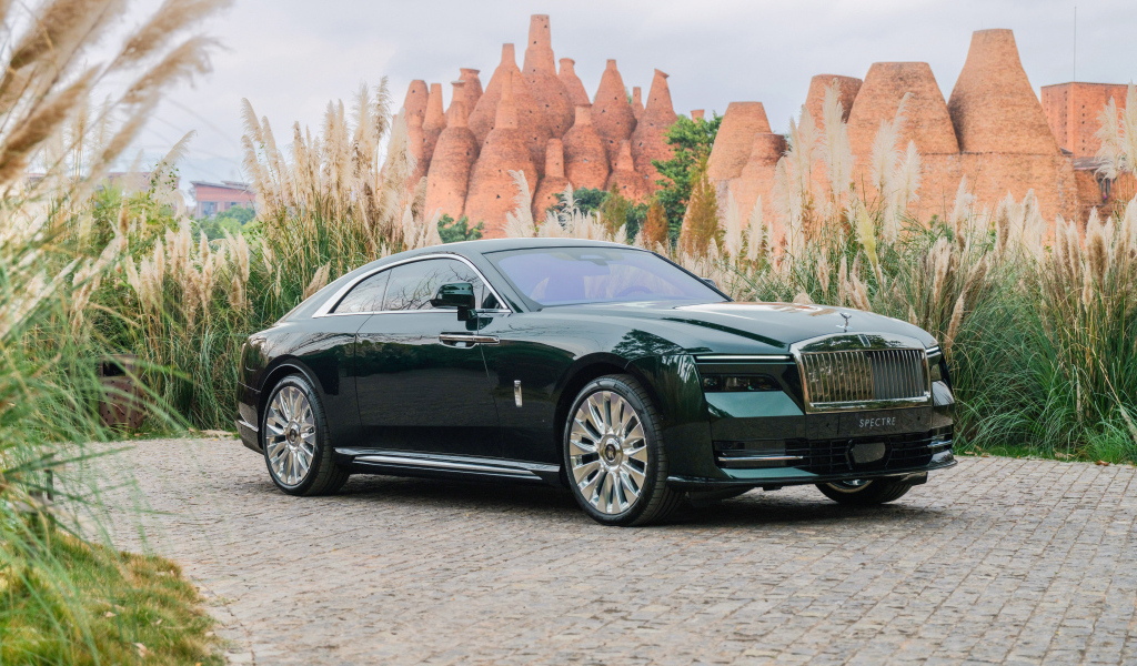 Дорогой зеленый автомобиль Rolls-Royce Spectre