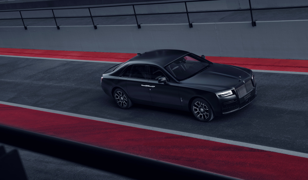 Черный автомобиль Rolls-Royce Black Badge Ghost на дороге