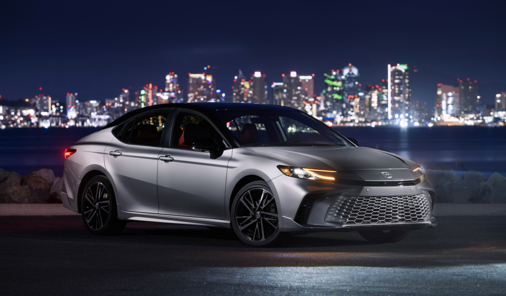 Новый автомобиль Toyota Camry XSE HEV AWD 2025 года на фоне города