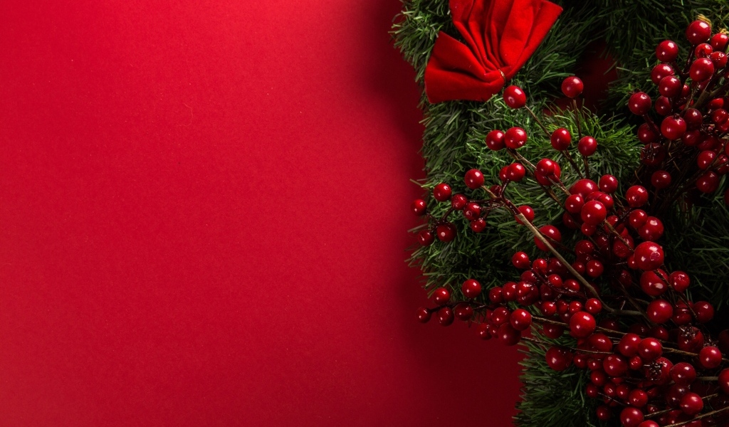 Красный фон с еловой веткой с ягодами