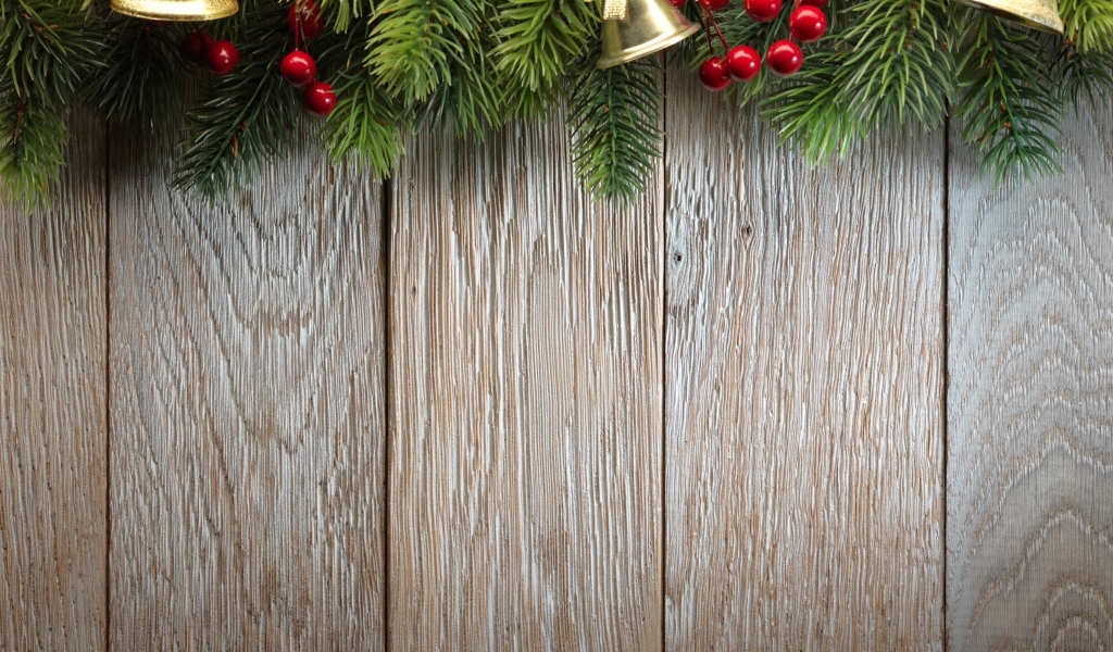 Деревянный новогодний фон с еловой веткой и колокольчиками