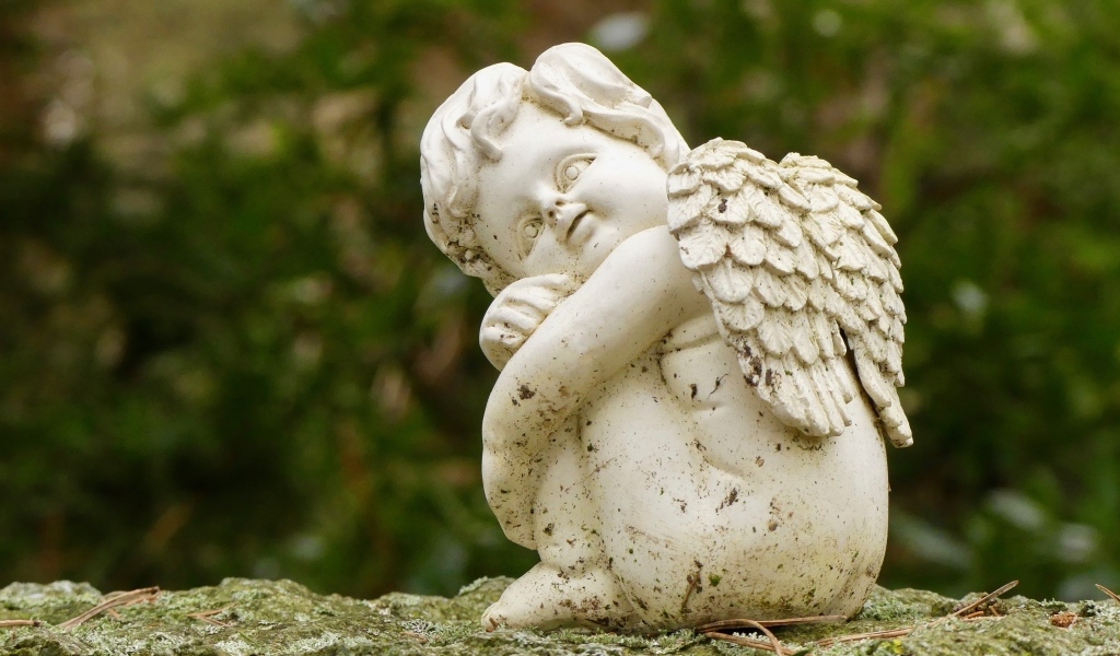 Статуэтка ангела стоит на камне