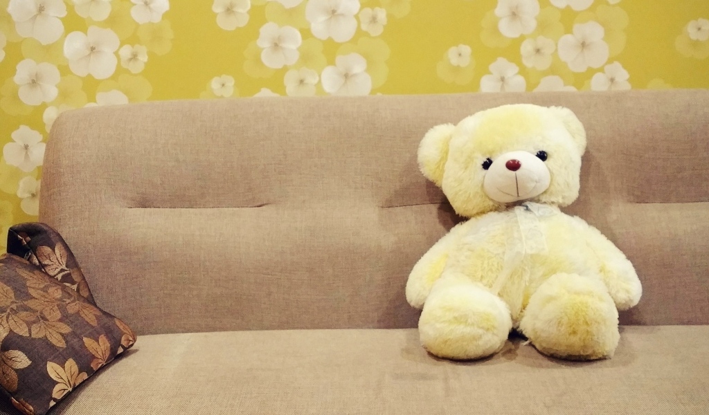 Милый игрушечный медведь на диване