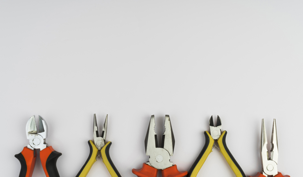 Разные плоскогубцы на сером фоне