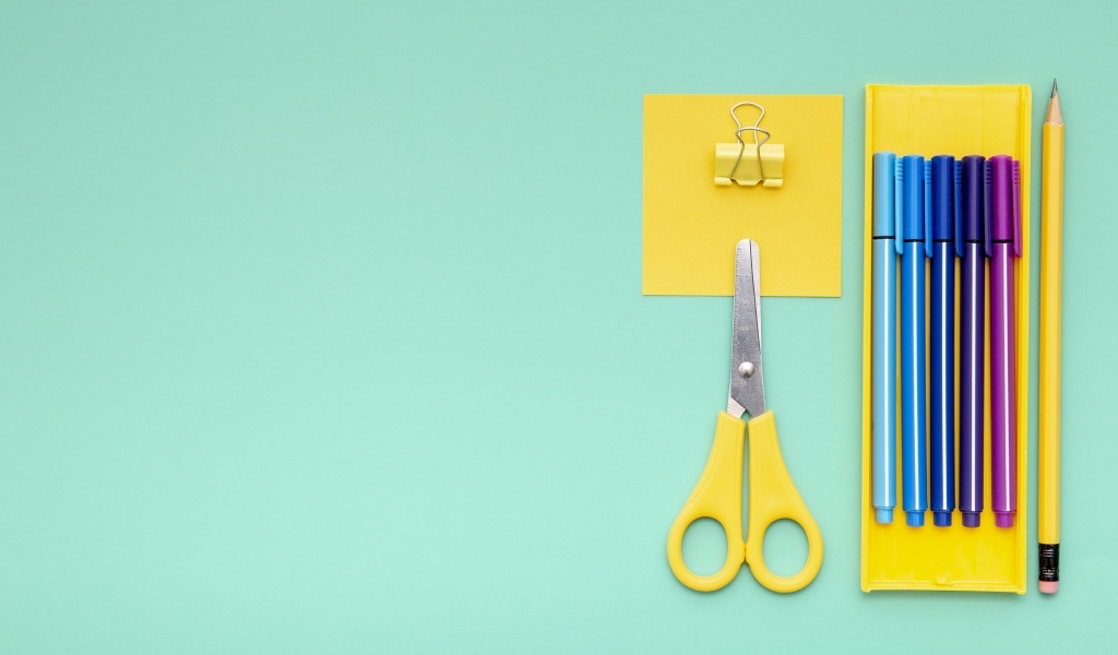 Фломастеры, ножницы и карандаш на голубом фоне