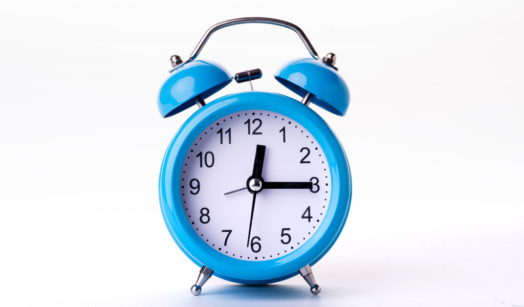 Большой голубой будильник на белом фоне