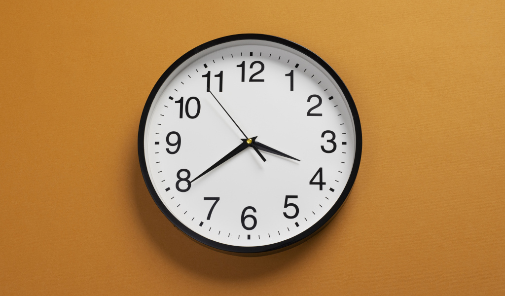 Большие круглые часы на желтом фоне