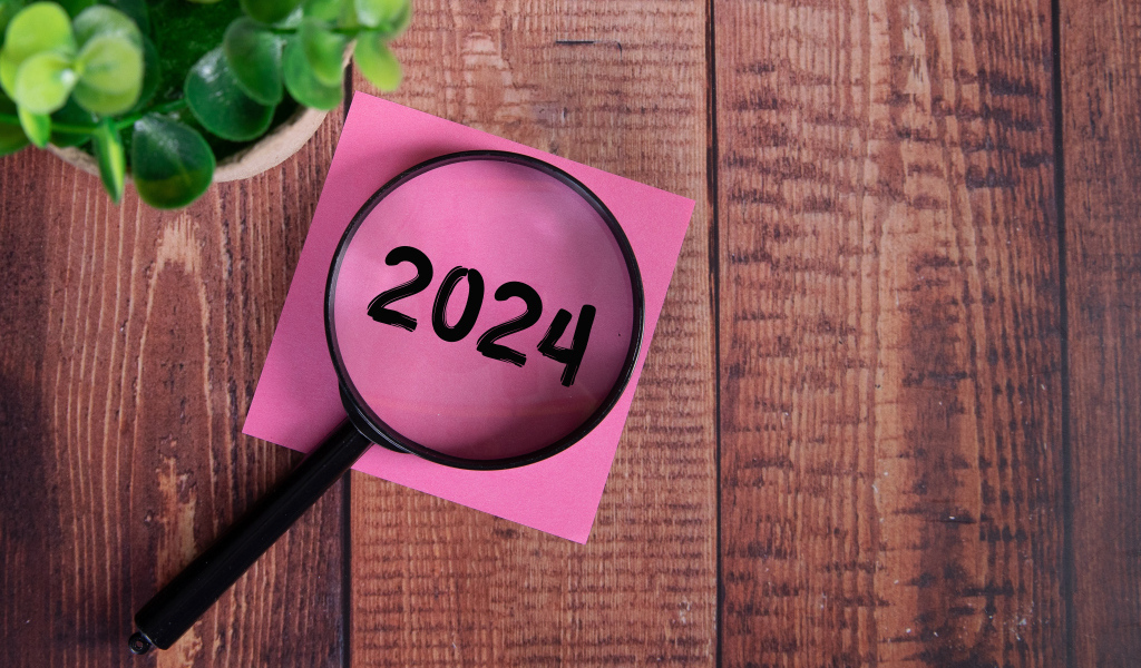 Увеличительное стекло с листом бумаги и цветком на столе