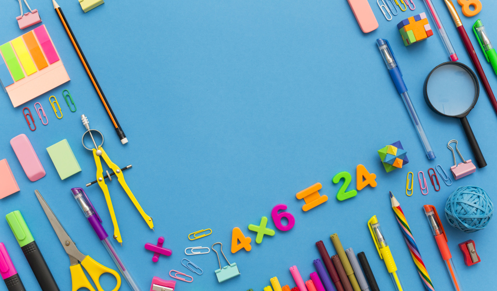 Много разных канцелярских предметов на голубом столе