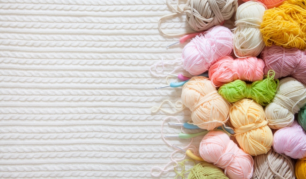 Разноцветная пряжа для вязания на белом трикотажном полотне