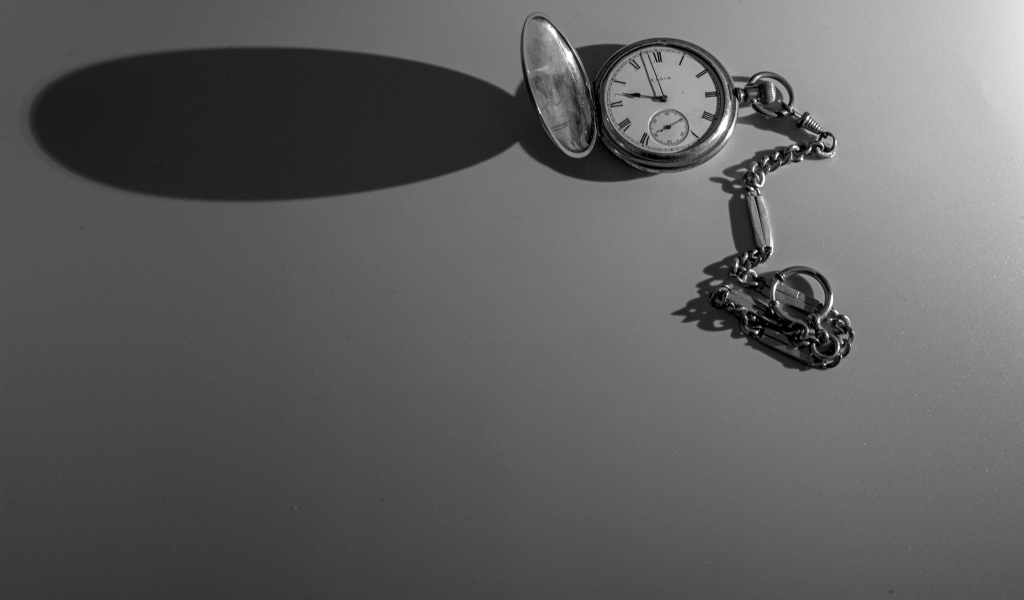 Тень от карманных часов на сером фоне