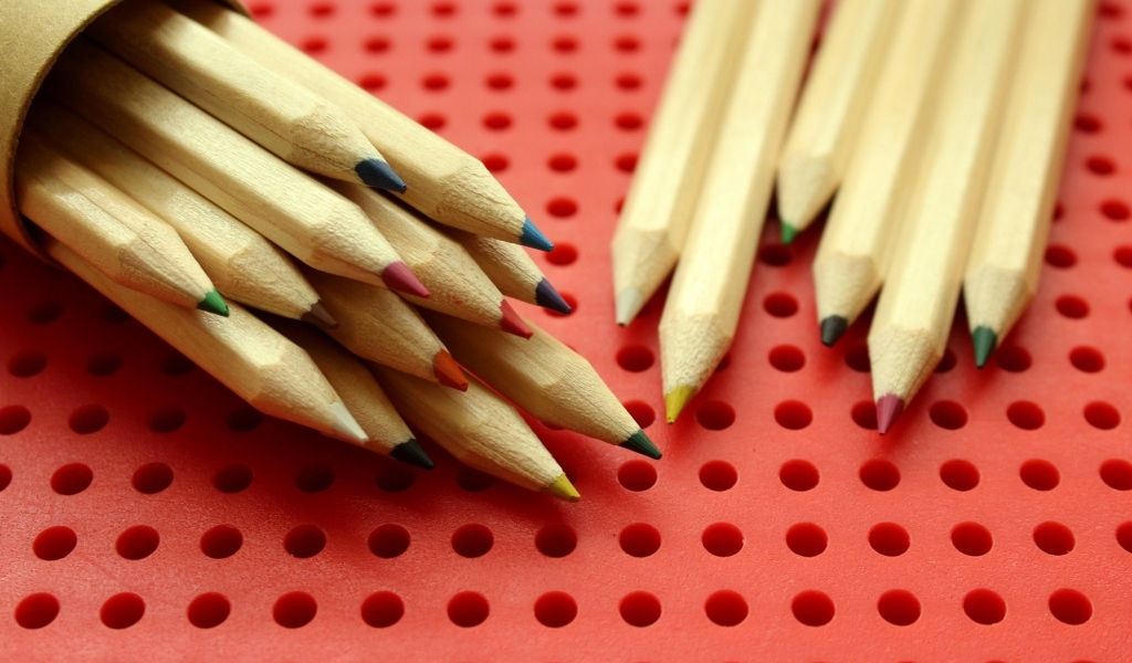 Заточенные карандаши на красном фоне