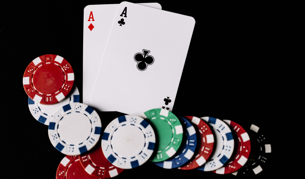 Два туза и фишки для покера  на черном фоне