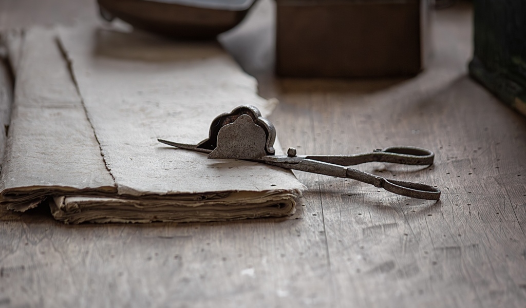 Старинные железные ножницы с бумагой на столе