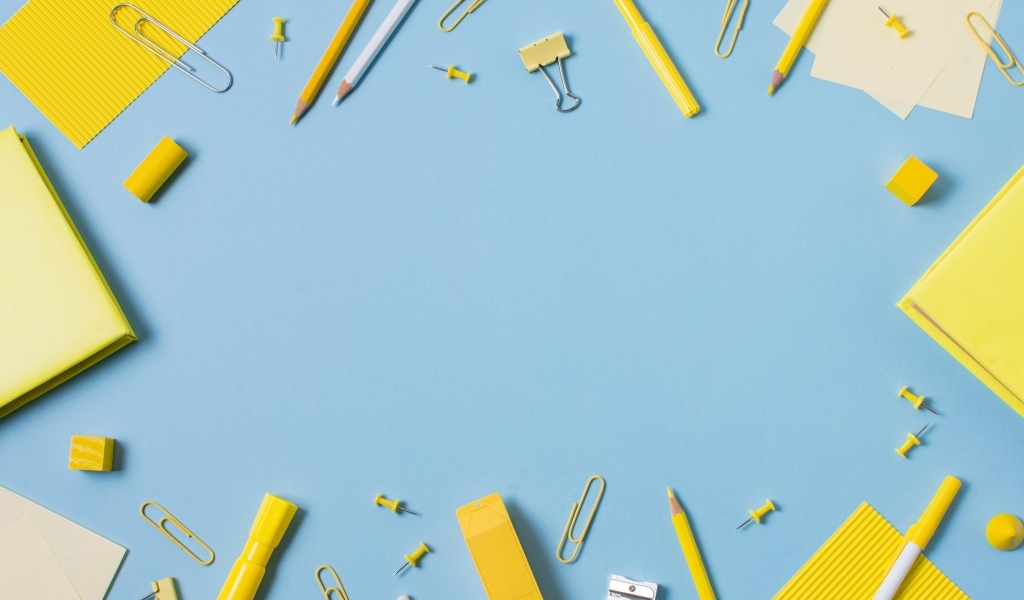 Желтые канцелярские предметы на голубом столе