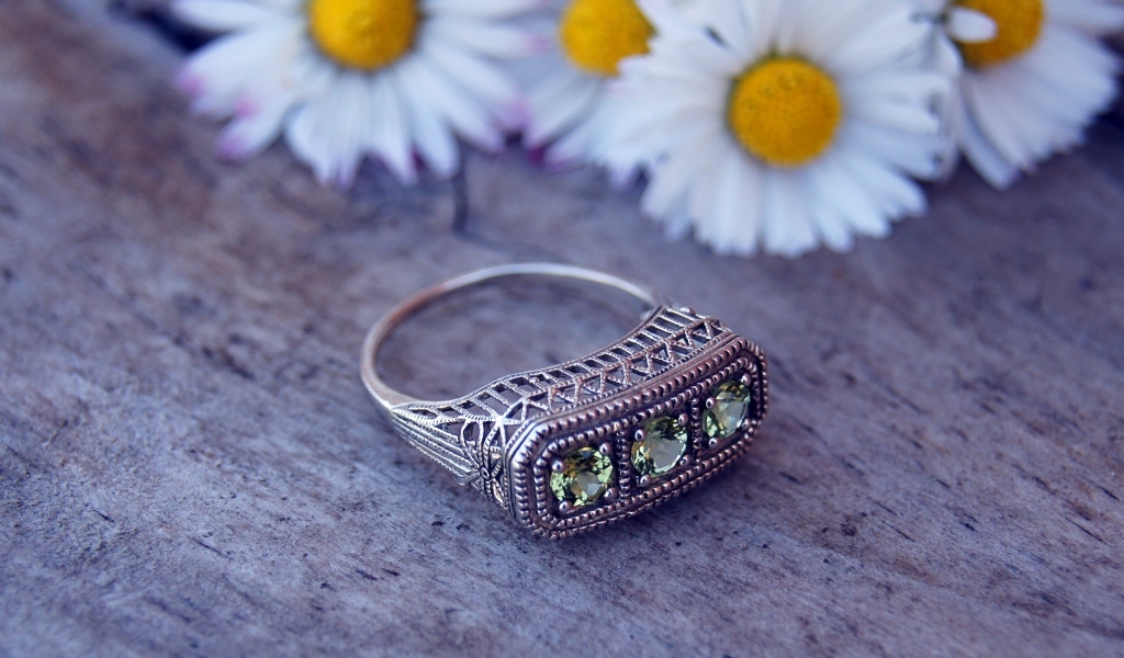 Старинный перстень на столе с ромашками