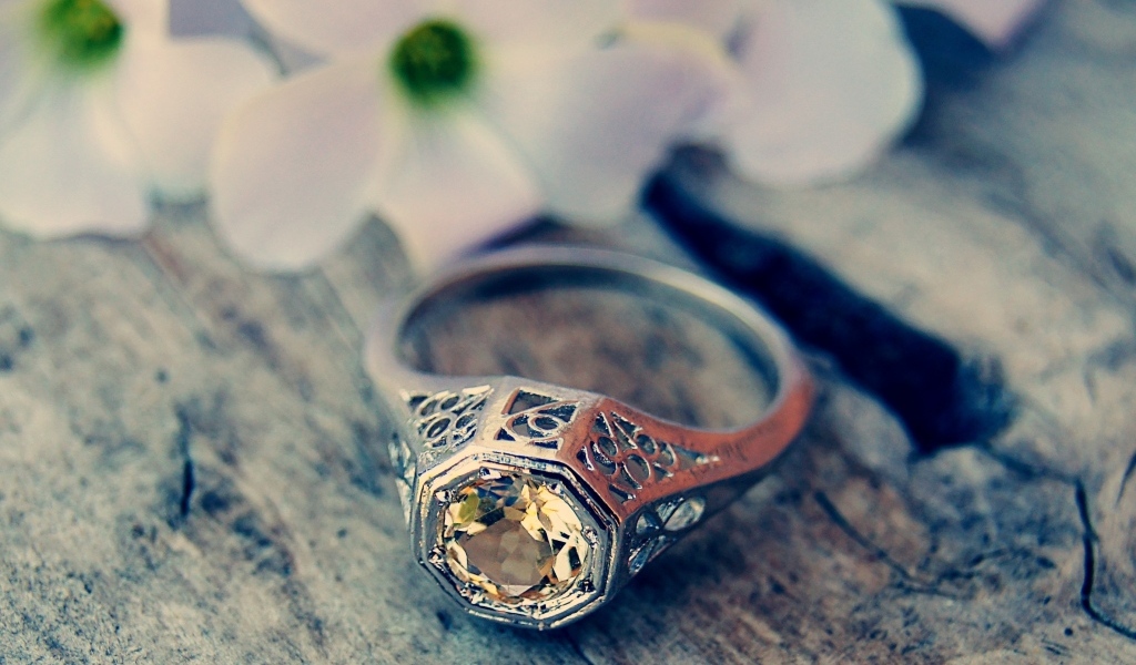 Перстень с камнем на деревянном столе 