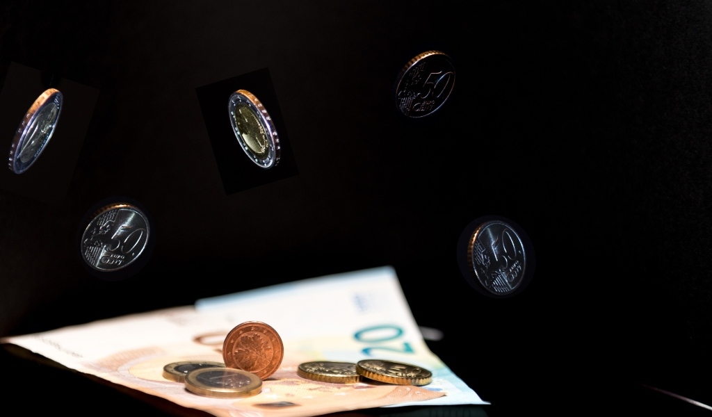 Купюры с монетами на черном фоне