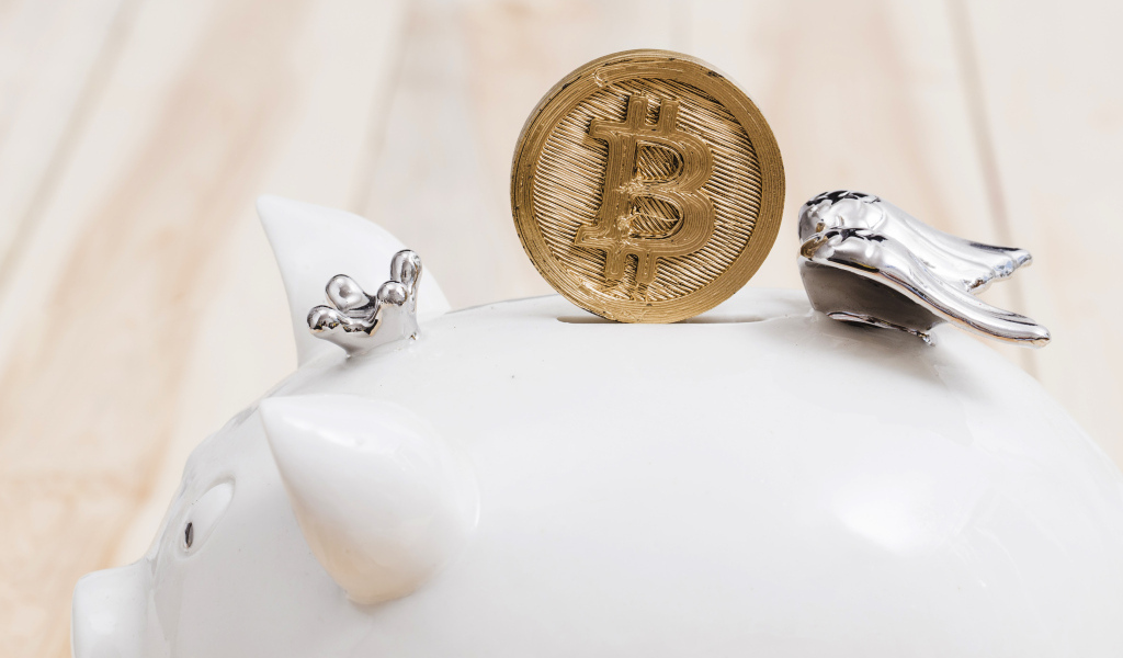 Золотая монета биткоин с копилкой