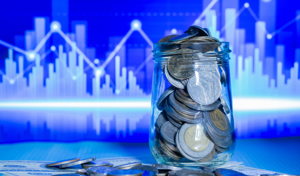 Банка с монетами на фоне таблицы