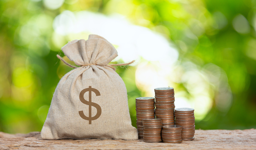 Мешок с деньгами на столе с монетами
