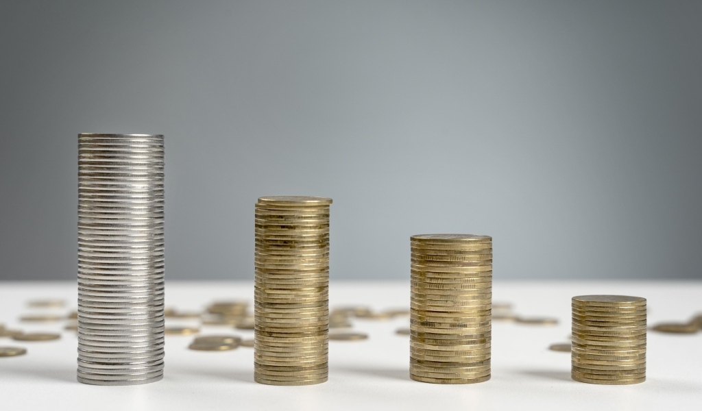 Стопки монет на сером фоне на столе