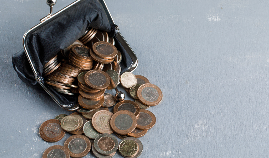 Кошелек с монетами на сером столе