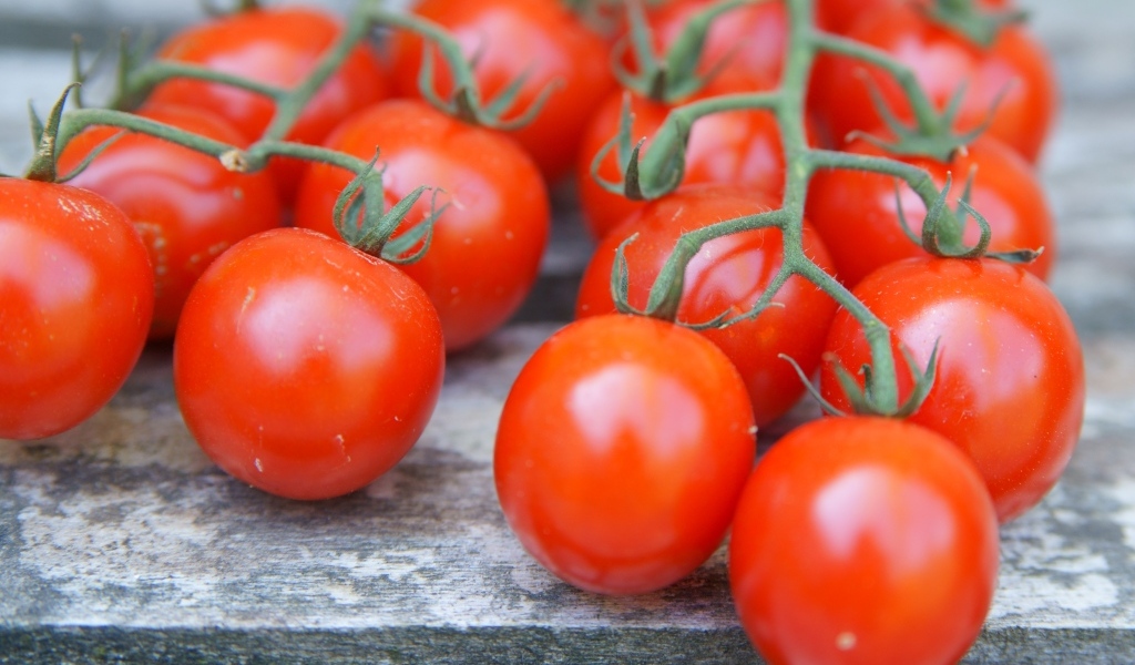 Веточки с красными помидорами на столе