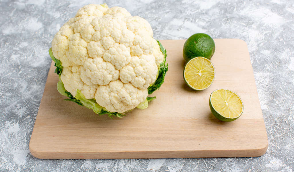 Цветная капуста с кусочками лайма на доске
