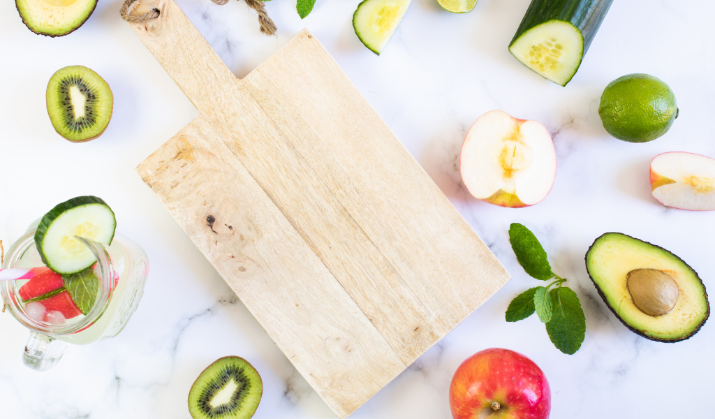 Разделочная доска с фруктами и овощами на столе