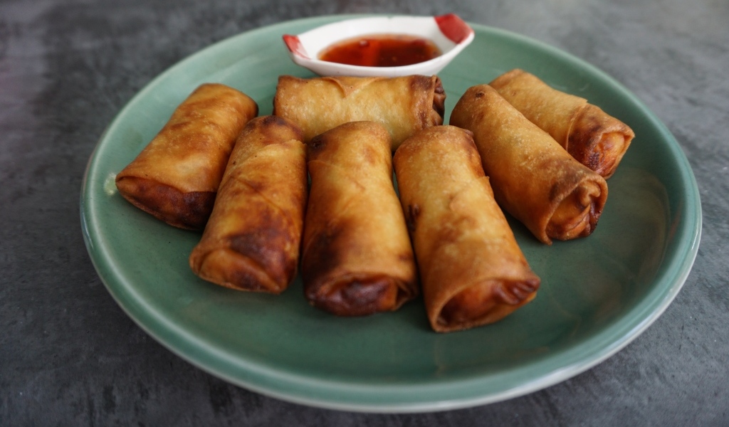 Яичные рулетики на большой тарелке с соусом